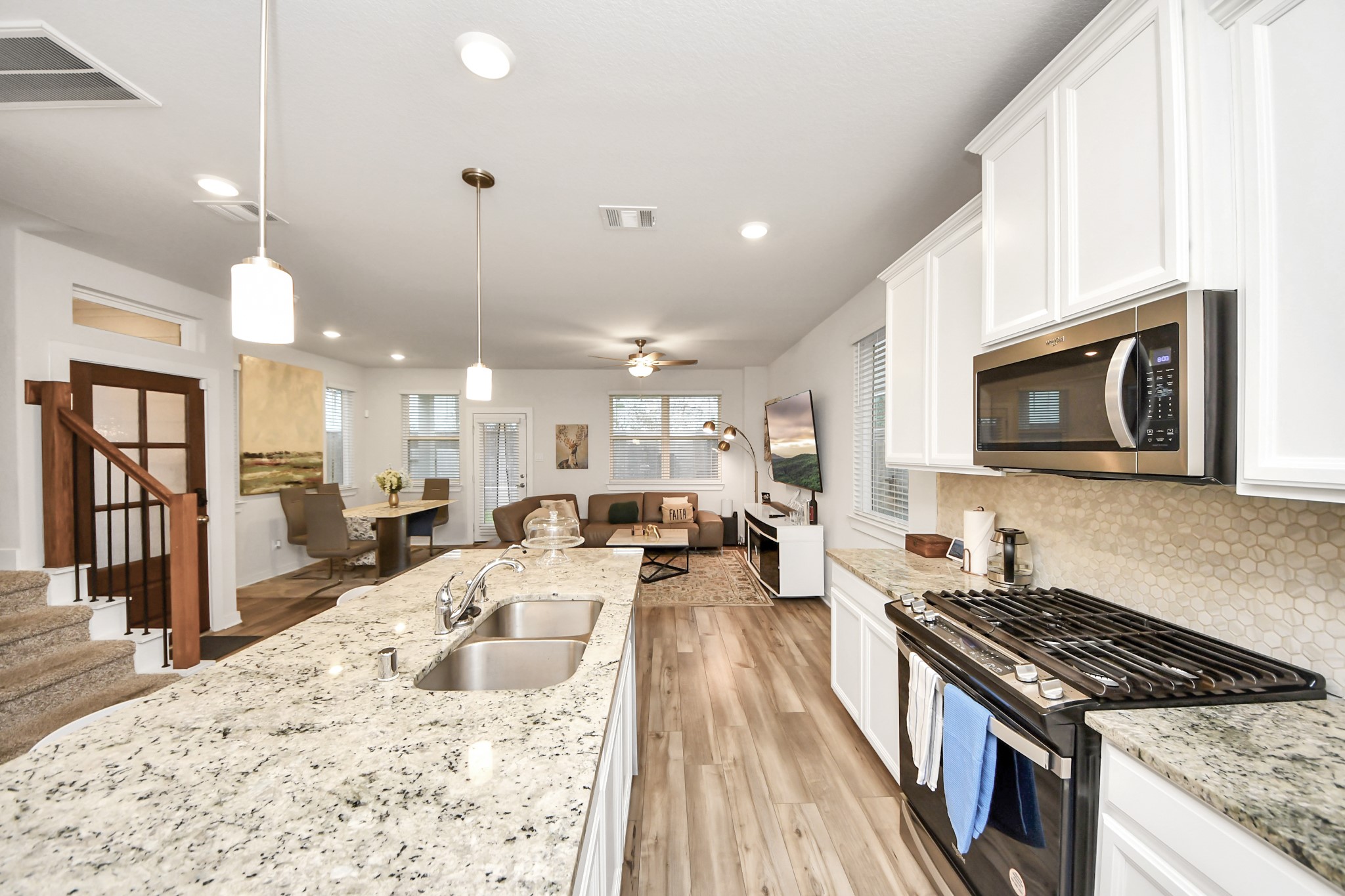 8207 Rising Stream Drive Houston, TX 77063 - Photo 17 of 50 a large kitchen with kitchen island a stove a sink dishwasher a dining table and chairs with wooden floor