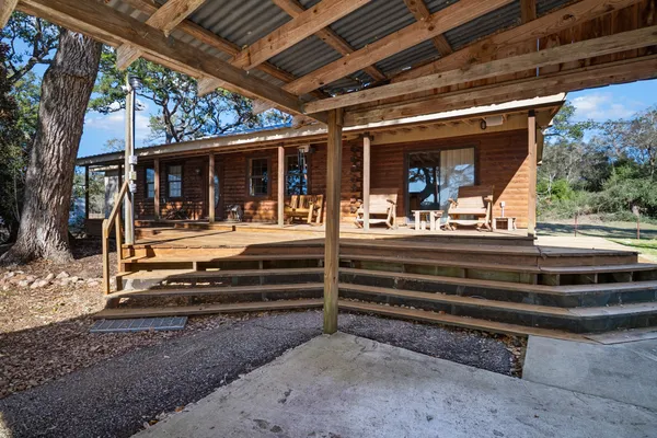 a view of backyard with large trees and a wooden fence