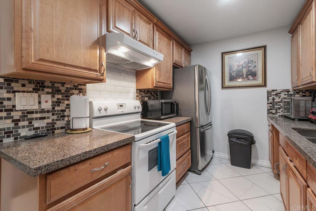 2340 Hosp Way, Unit 120 Carlsbad, CA 92008 - Photo 13 of 33 a kitchen with stainless steel appliances granite countertop a stove and a refrigerator