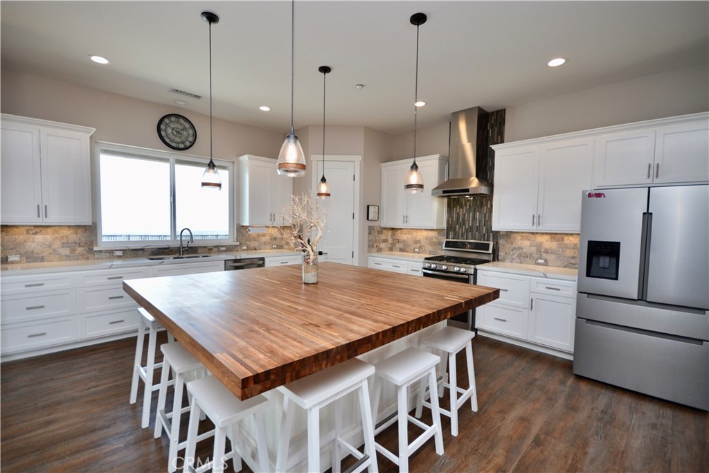 12451 Rancho Heights Road Pala, CA 92059 - Photo 3 of 46 a kitchen with a table chairs refrigerator and microwave