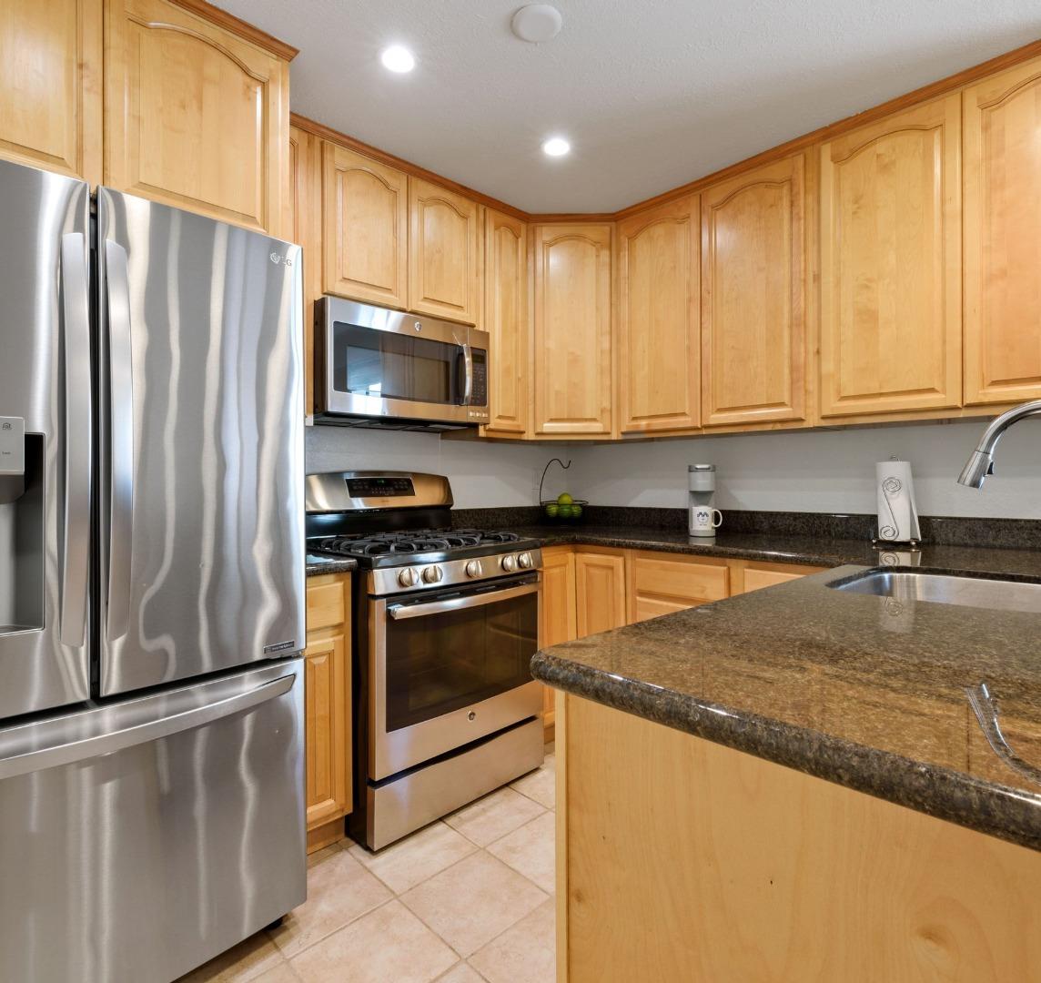 1276 Rosita Road Pacifica, CA 94044 - Photo 3 of 13 a kitchen with stainless steel appliances granite countertop a refrigerator a stove a sink and a microwave