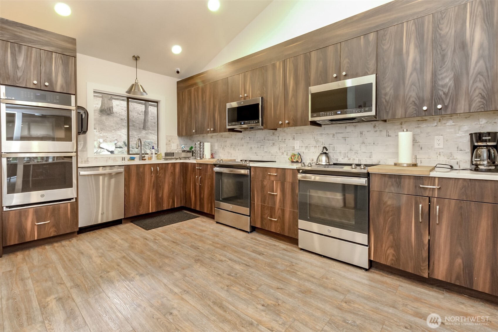 2500 South 370th Street, Unit 54 Federal Way, WA 98003 - Photo 28 of 40 a kitchen with stainless steel appliances granite countertop a stove top oven a sink dishwasher and a refrigerator with wooden floor