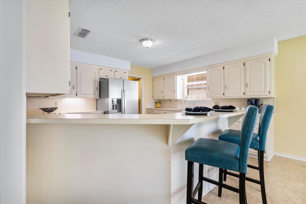 2824 Crestview Avenue Tyler, TX 75701 - Photo 10 of 39 a kitchen with stainless steel appliances granite countertop a table chairs sink and cabinets