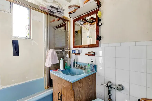 a bathroom with a granite countertop sink a mirror and shower