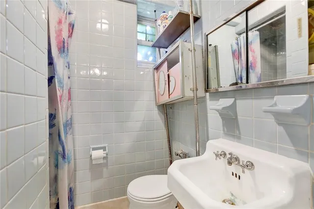 a white toilet sitting next to a bathroom sink