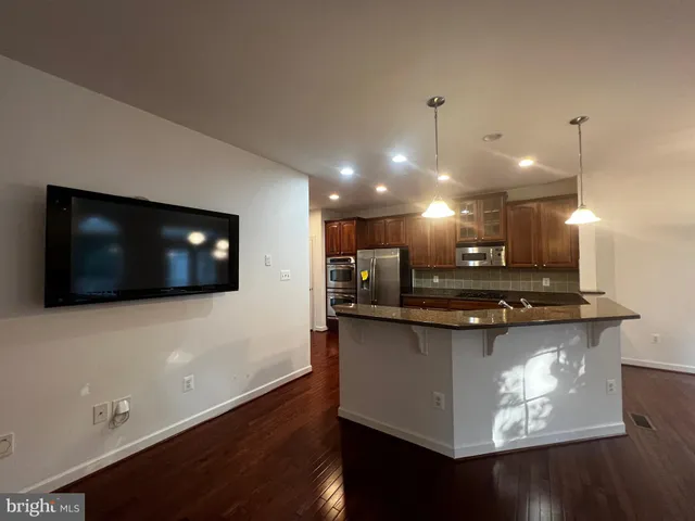 a view of a living room and kitchen with a wooden floor