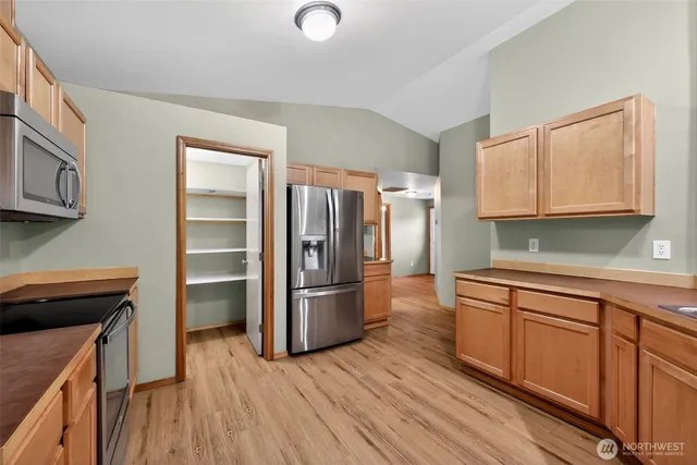 a kitchen with stainless steel appliances a refrigerator and a stove top oven