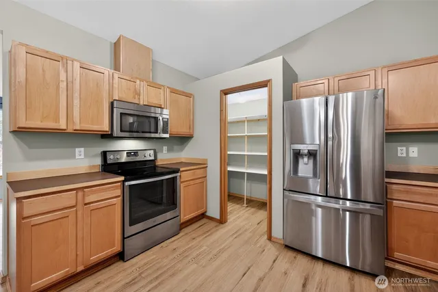a kitchen with stainless steel appliances granite countertop a refrigerator microwave and sink