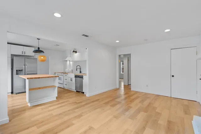 a view of a kitchen with a sink and a refrigerator