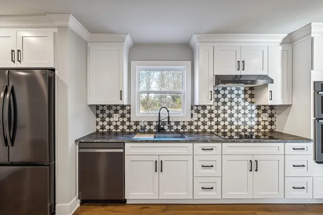 a view of an empty room with wooden floor and window