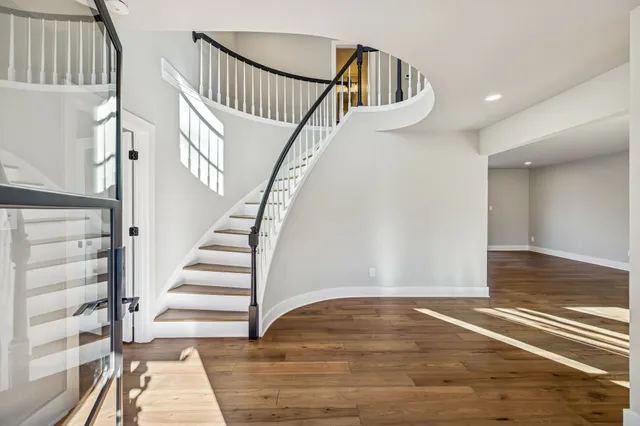 a view of a big room with wooden floor and windows