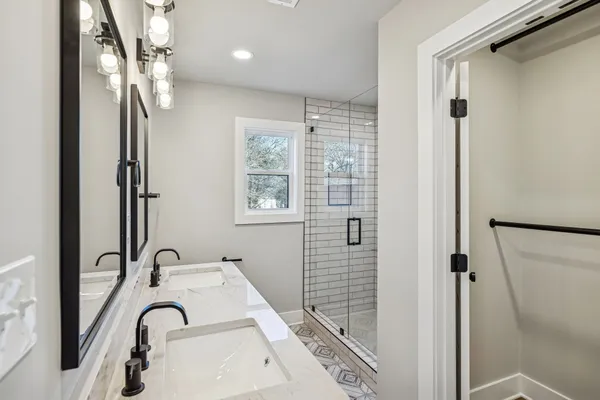 a bathroom with a sink a mirror and a shower