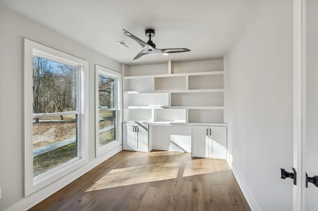 a view of empty room with wooden floor and floor to ceiling window