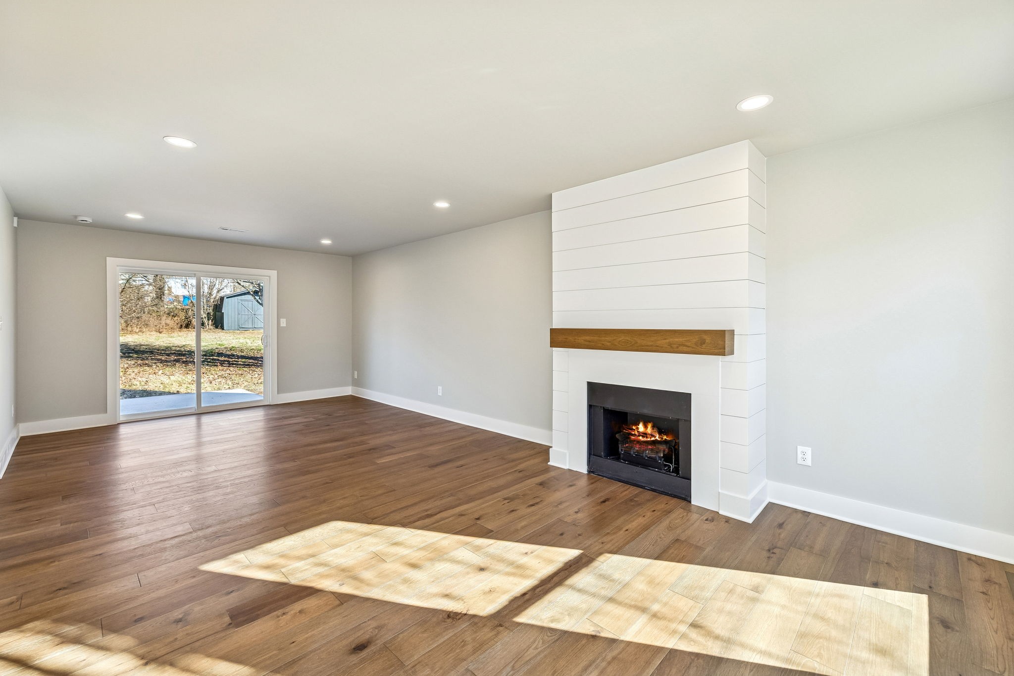 628 Vaughan's Gap Road Spring Hill, TN 37174 - Photo 10 of 45 a view of an empty room with wooden floor fireplace and a window