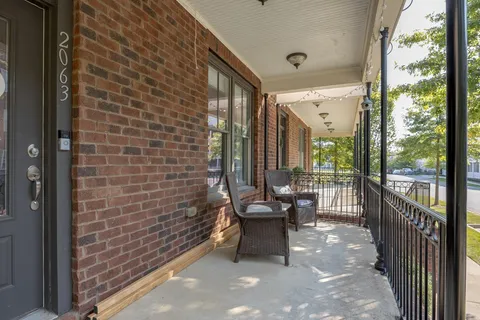 a balcony with chairs and with potted plants
