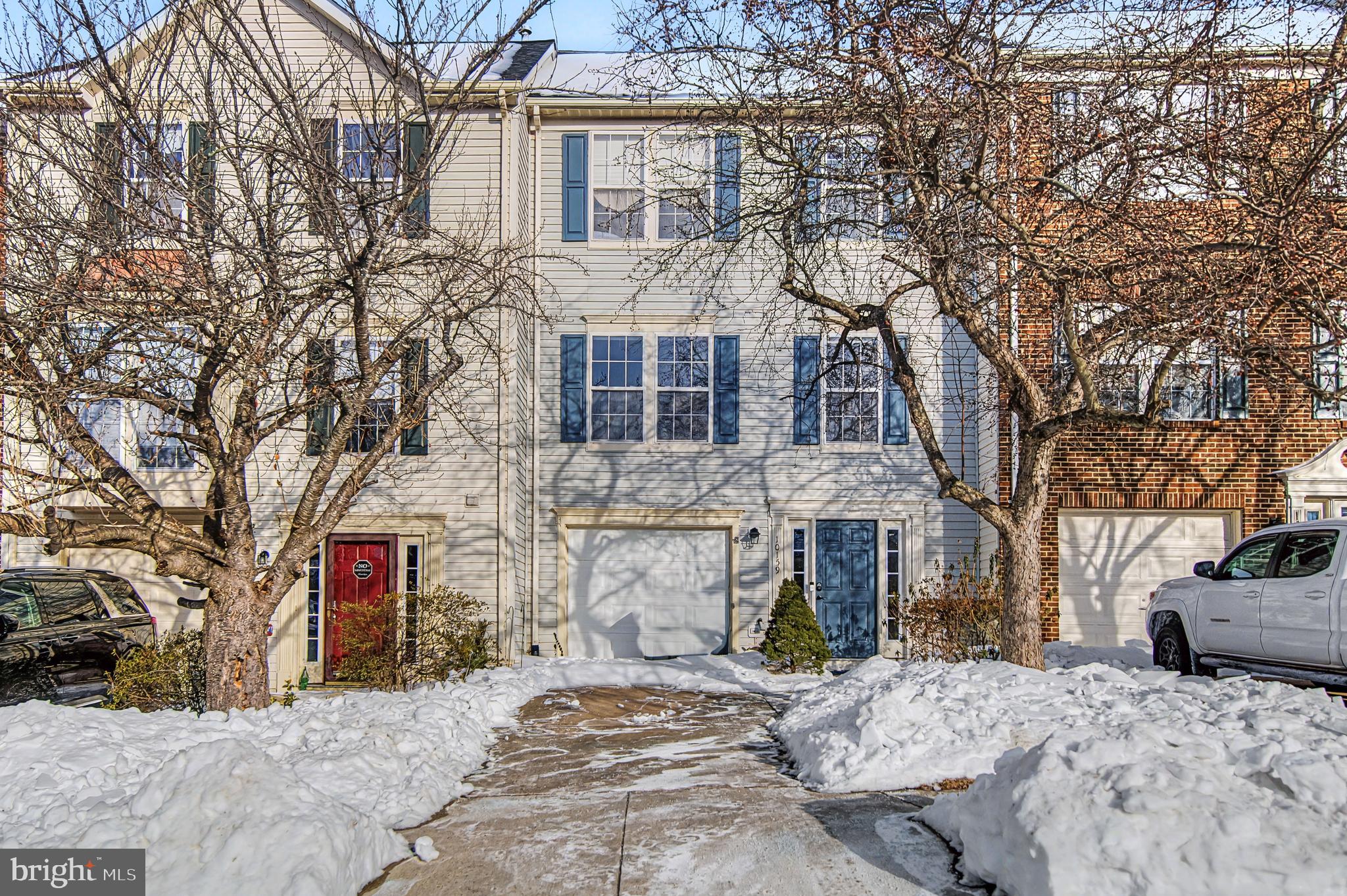 a front view of a house with cars parked