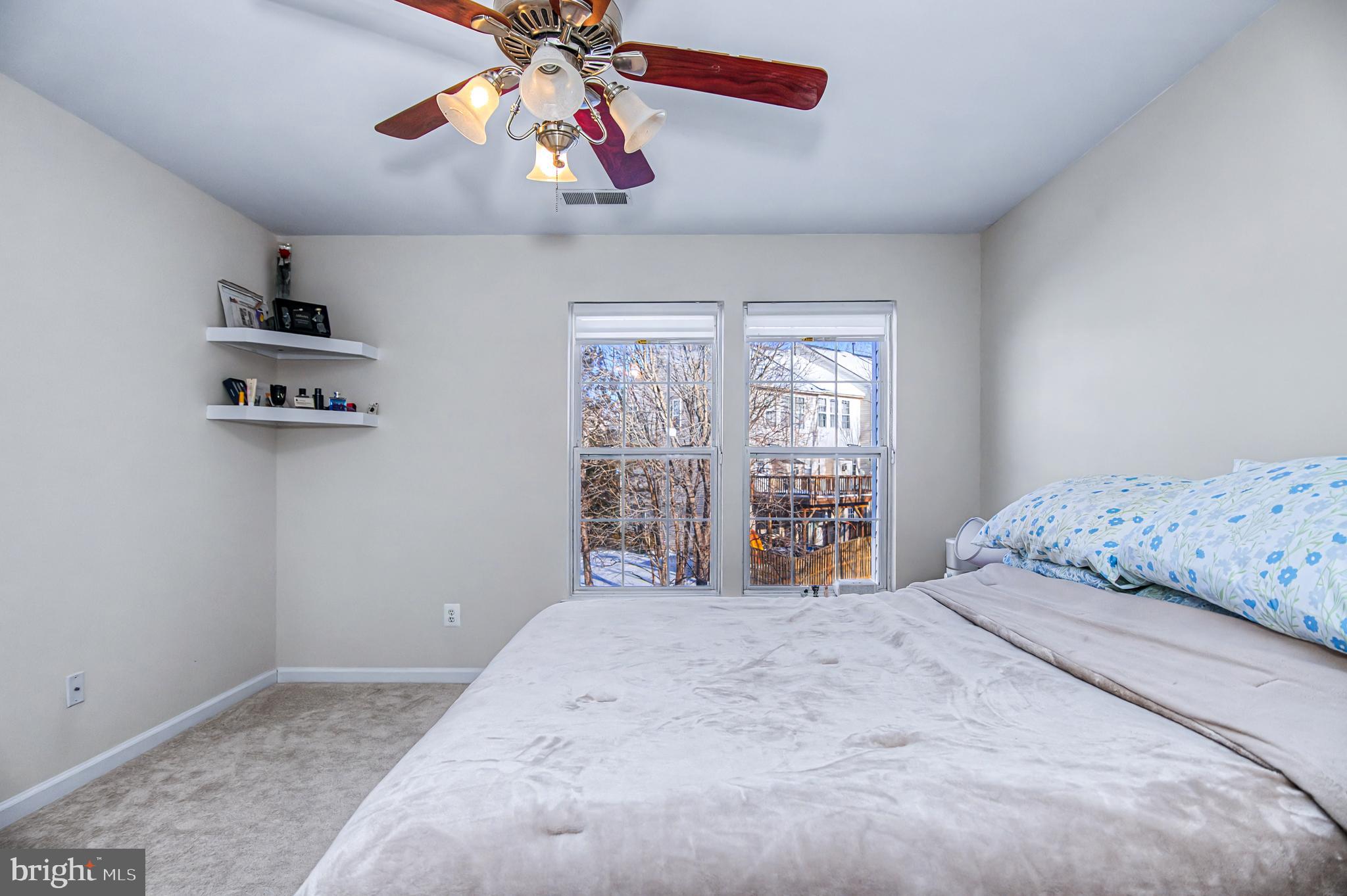 10159 Elgin Way Bristow, VA 20136 - Photo 17 of 41 a bedroom with a large bed and a chandelier