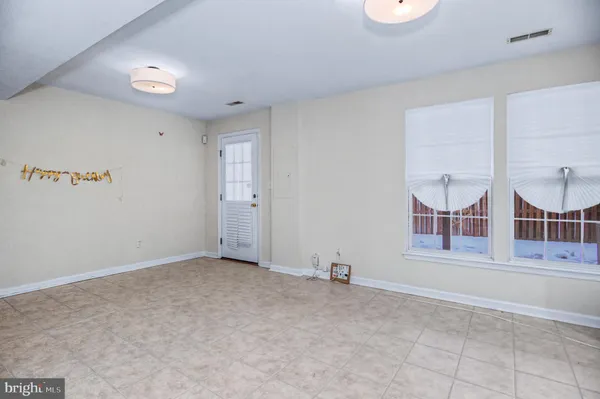 an empty room with windows and fireplace