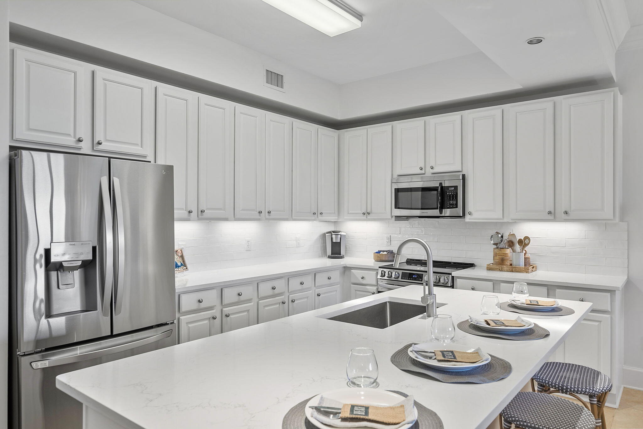 1653 West County Highway 30A, Unit 2105 Santa Rosa Beach, FL 32459 - Photo 4 of 42 a kitchen with stainless steel appliances a white table and chairs