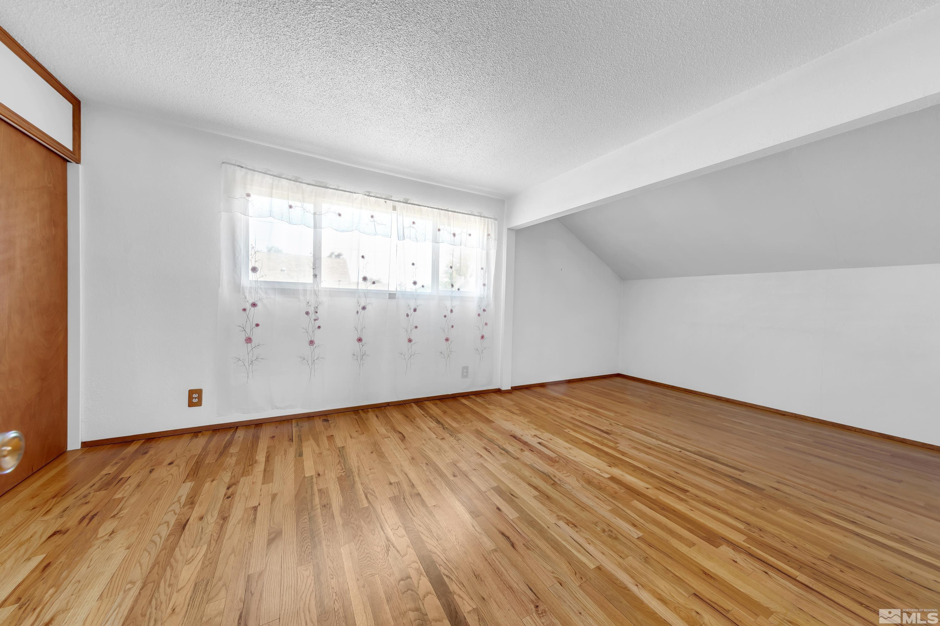 2555 Dyer Way Reno, NV 89512 - Photo 13 of 18 an empty room with wooden floor