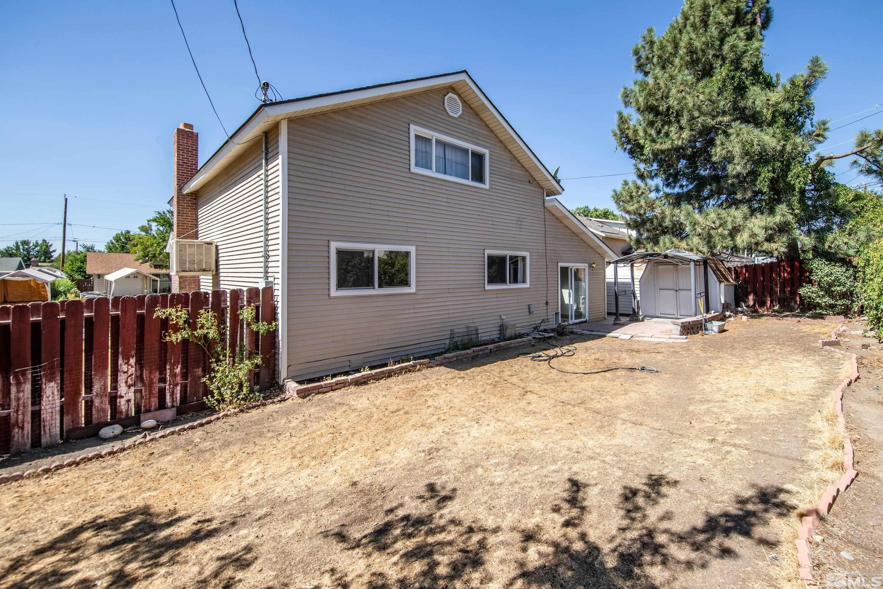 2555 Dyer Way Reno, NV 89512 - Photo 17 of 18 a backyard of house with trees and wooden fence