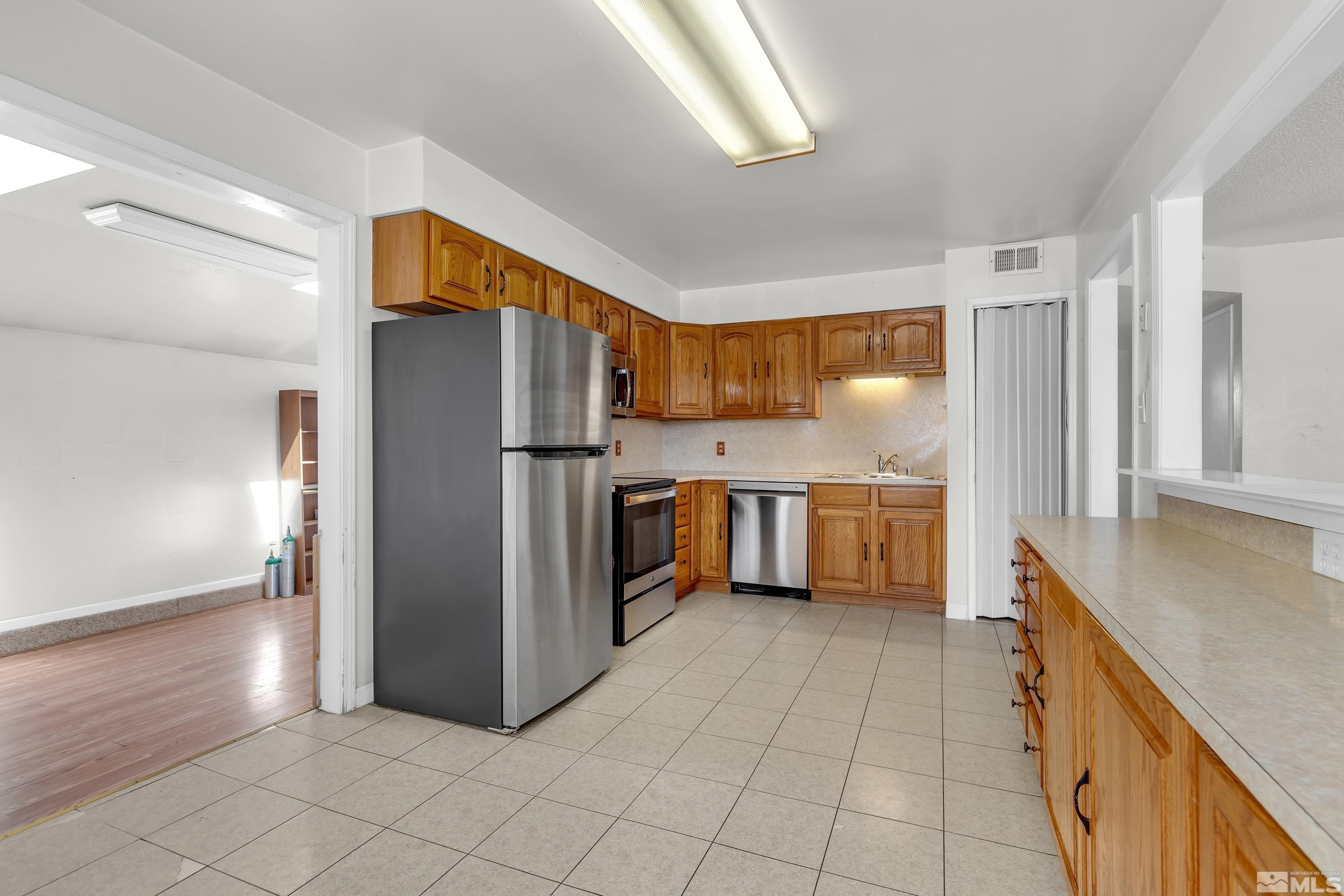 2555 Dyer Way Reno, NV 89512 - Photo 3 of 18 a kitchen with stainless steel appliances a refrigerator and a sink