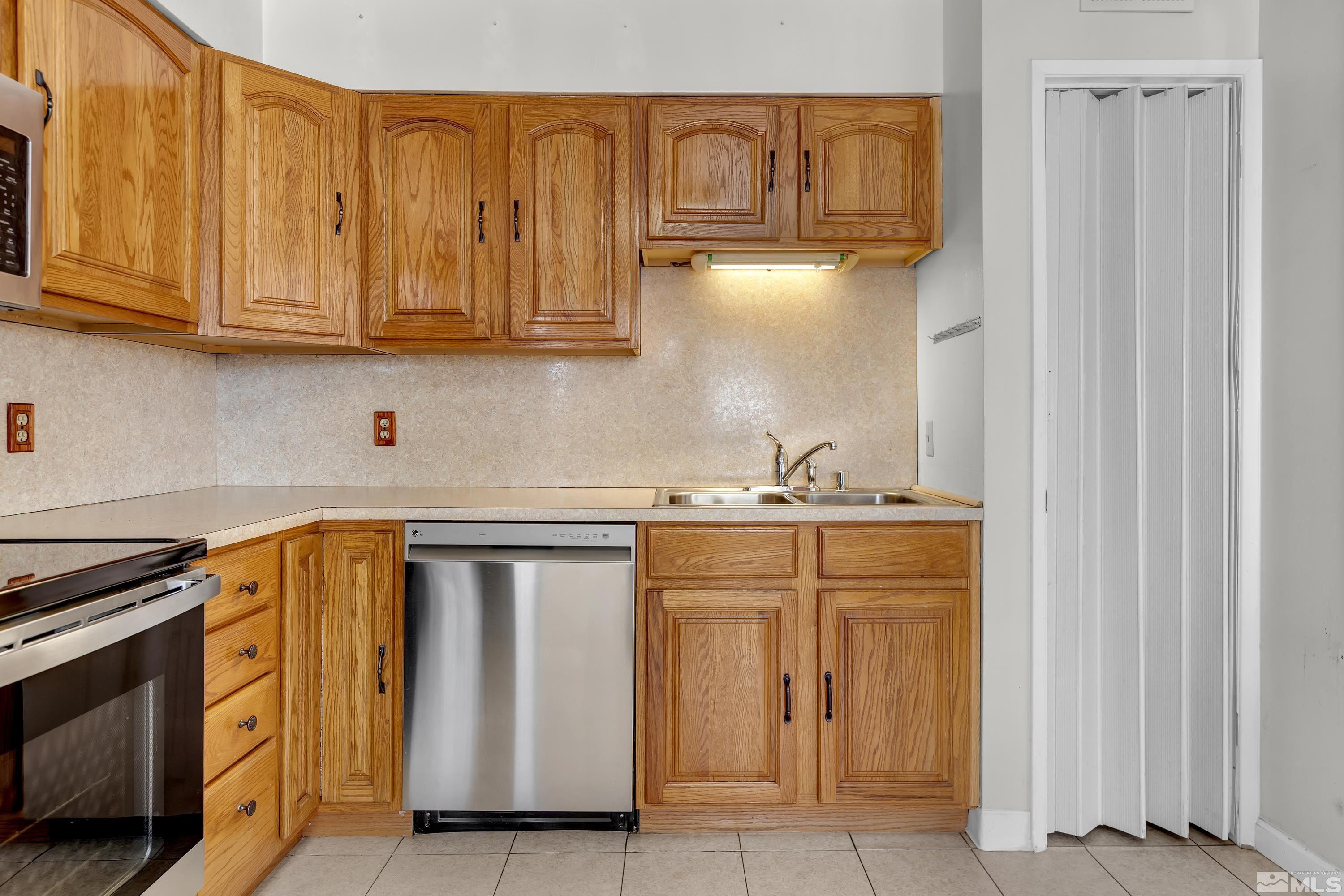2555 Dyer Way Reno, NV 89512 - Photo 4 of 18 a utility room with stainless steel appliances granite countertop a sink and a cabinets