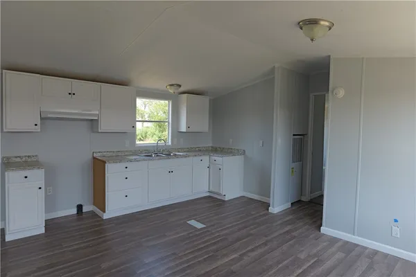 an empty room with wooden floor and window