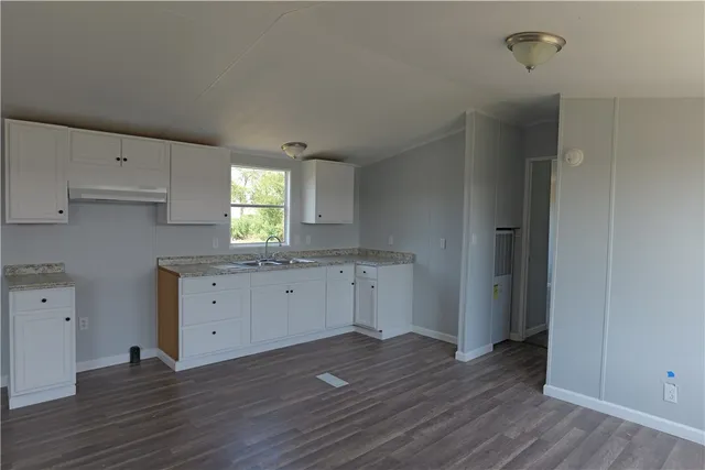an empty room with wooden floor and window