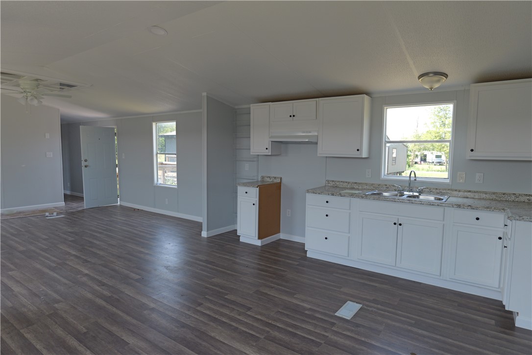 732 D Rogers Street Normangee, TX 77871 - Photo 5 of 12 a kitchen with wooden floors and white cabinets