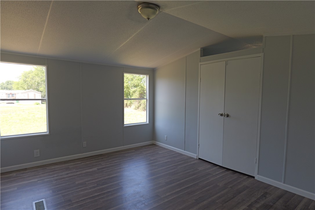 732 D Rogers Street Normangee, TX 77871 - Photo 7 of 12 an empty room with wooden floor and windows