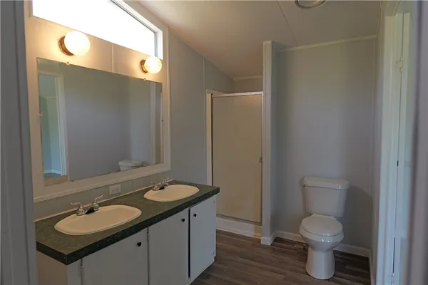 a bathroom with a granite countertop toilet sink and mirror