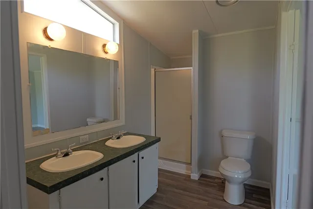a bathroom with a granite countertop toilet sink and mirror