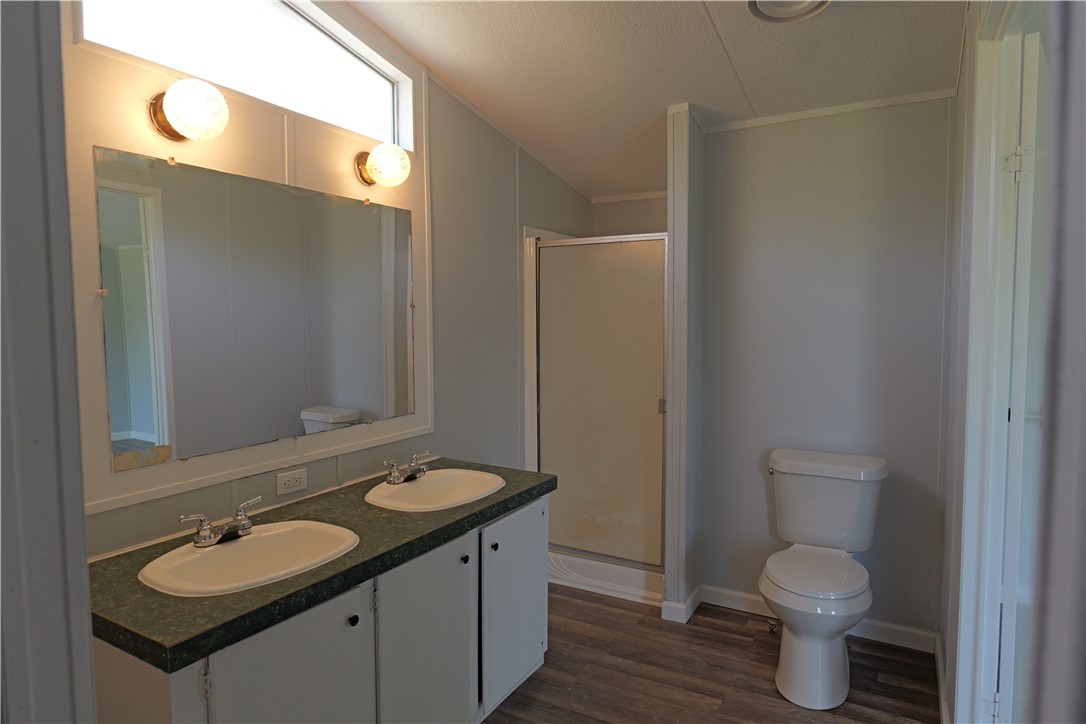 732 D Rogers Street Normangee, TX 77871 - Photo 8 of 12 a bathroom with a granite countertop toilet sink and mirror