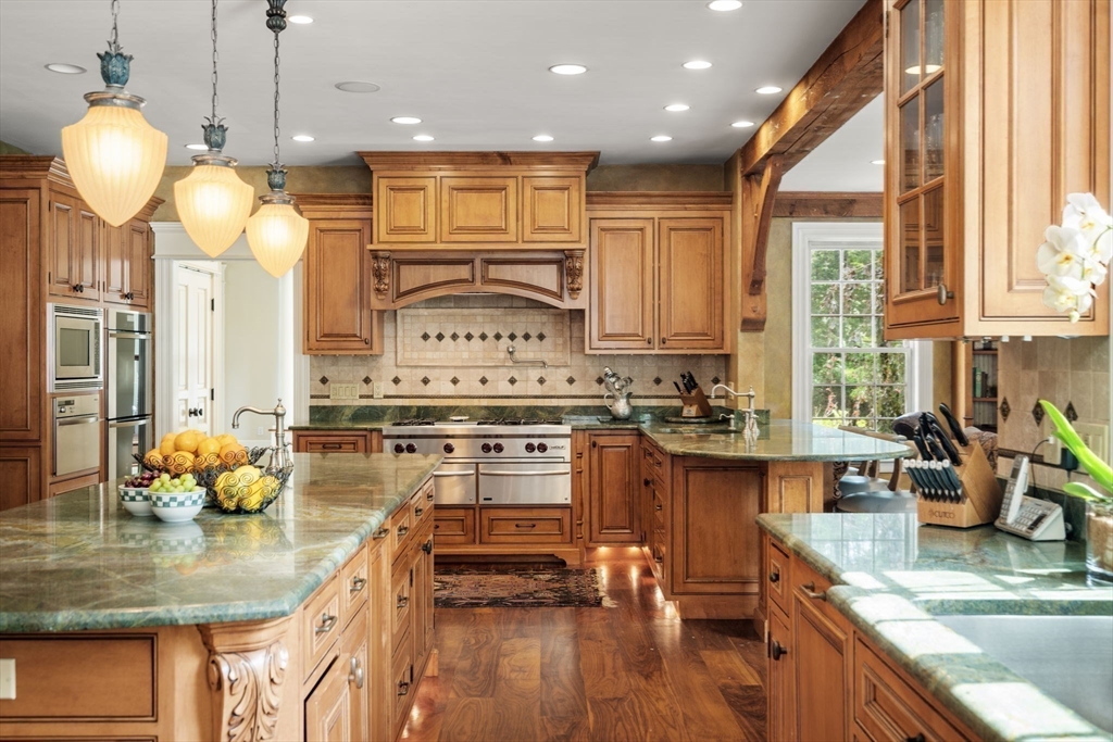 3 Stone Bridge Lane Milton, MA 02186 - Photo 13 of 37 a kitchen with stainless steel appliances kitchen island granite countertop a stove a sink and a granite counter tops with white cabinets
