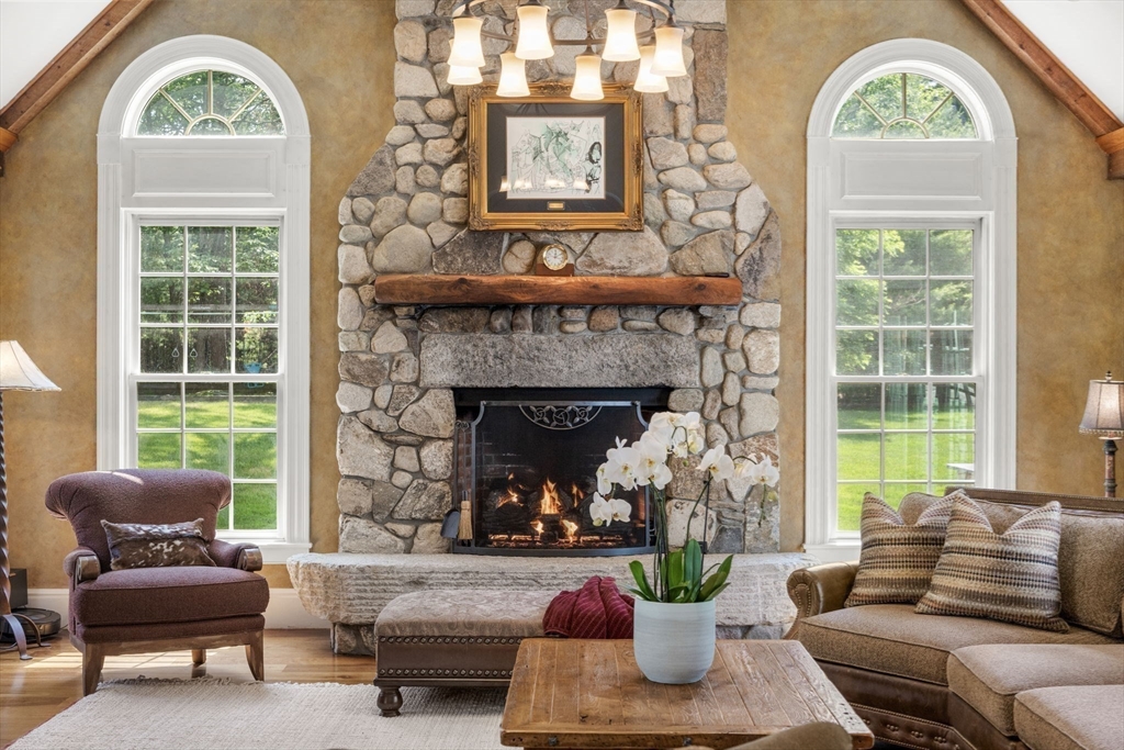 3 Stone Bridge Lane Milton, MA 02186 - Photo 17 of 37 a living room with furniture a fireplace a potted plant and a large window