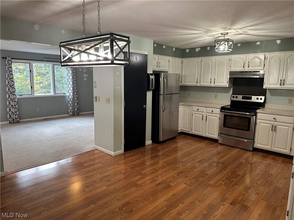 6715 Crosse Road Amherst, OH 44001 - Photo 2 of 21 Kitchen featuring white cabinets, dark hardwood floors, fume extractor, and appliances with stainless steel finishes