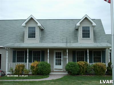 front view of a brick house with a yard