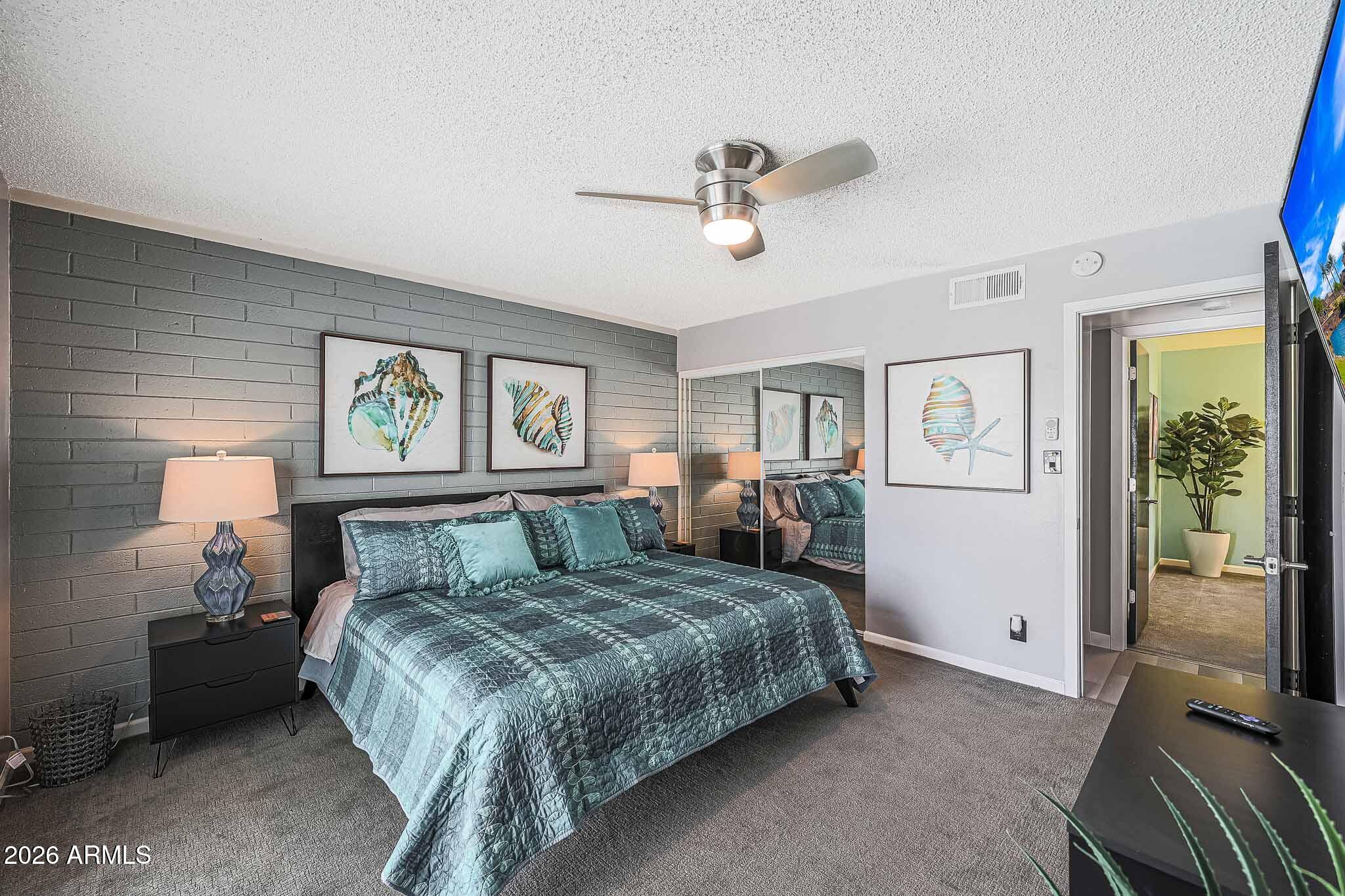 2201 East Marilyn Road Phoenix, AZ 85022 - Photo 29 of 47 a bedroom with a large bed and a chandelier