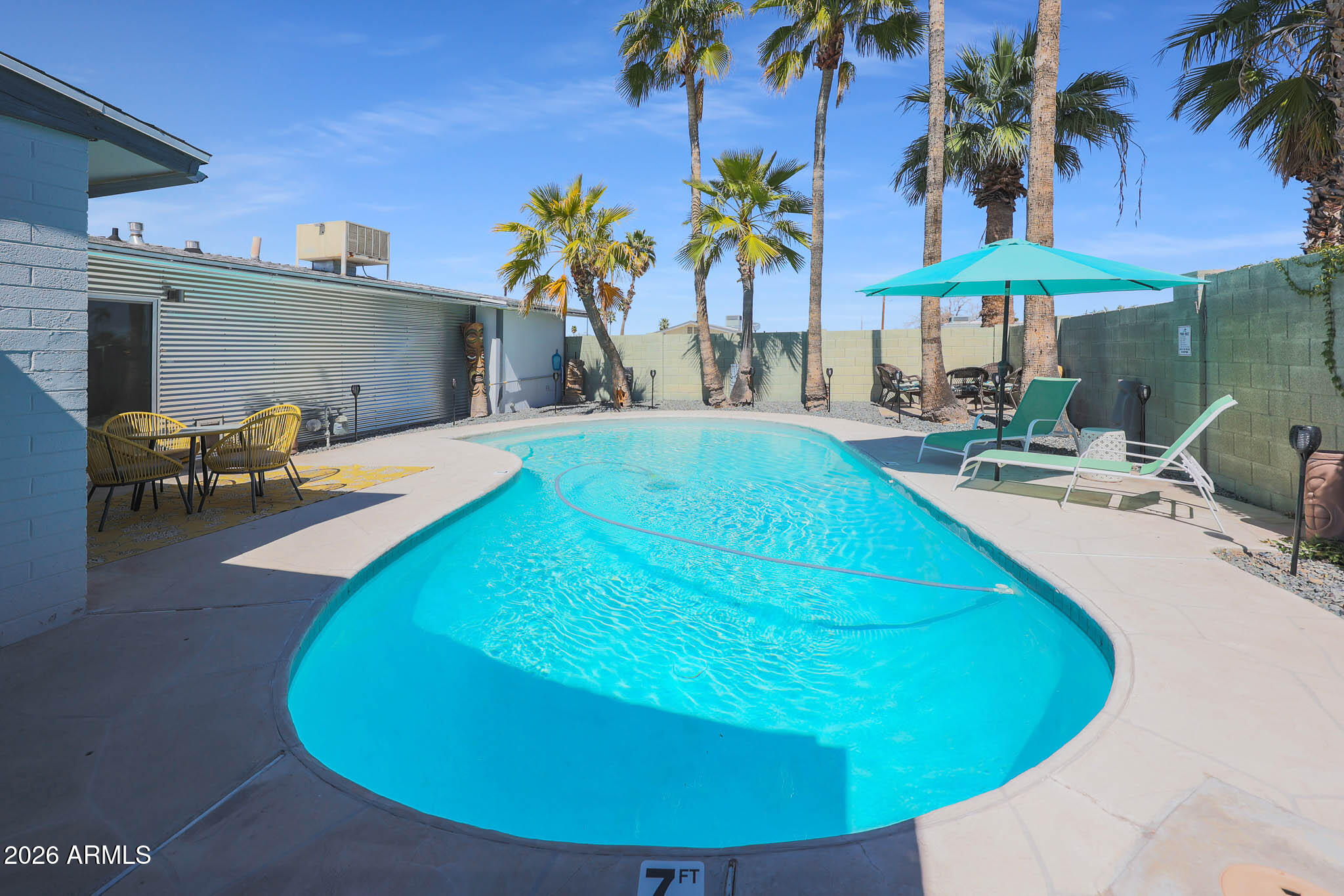 2201 East Marilyn Road Phoenix, AZ 85022 - Photo 38 of 47 a view of a swimming pool with a table and chairs under an umbrella