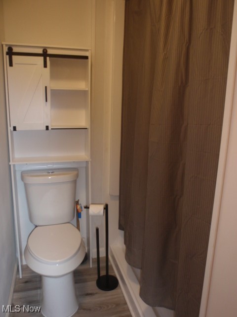 14203 Darrow Road Vermilion, OH 44089 - Photo 12 of 26 Bathroom featuring baseboards, wood finished floors, a shower stall, and toilet