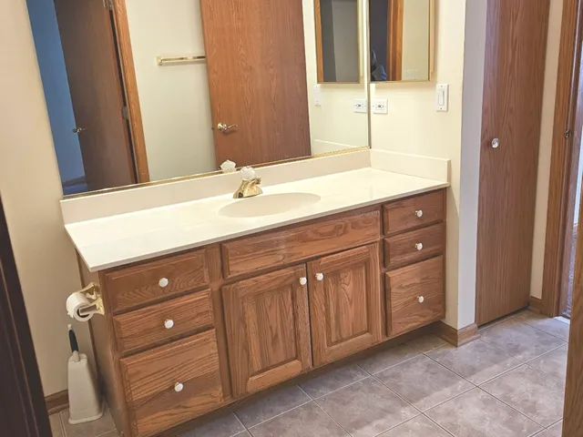 a bathroom with a granite countertop sink and a mirror