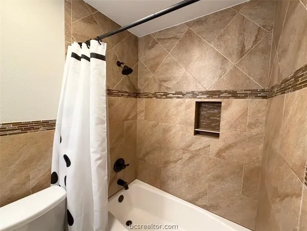 a bathroom with a granite countertop toilet sink and mirror