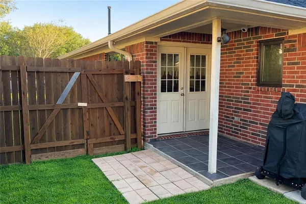 a view of a house with backyard and wooden fence