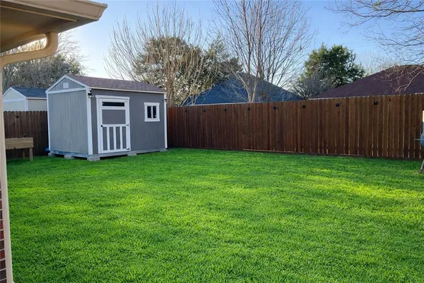 a view of a house with a yard and wooden fence