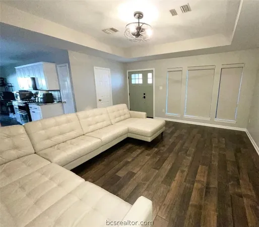 a kitchen with stainless steel appliances granite countertop a stove top oven a sink a dining table and chairs with wooden floor