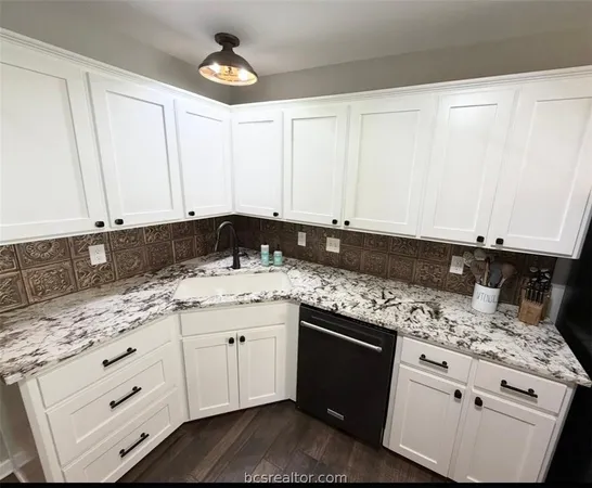 a kitchen with granite countertop white cabinets and appliances
