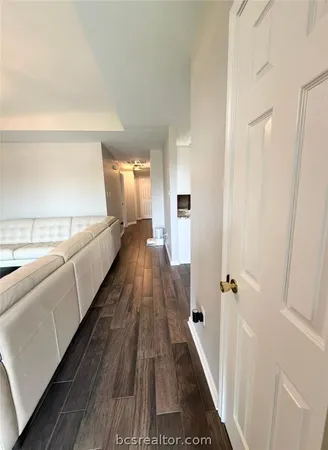 a bedroom with a bed a desk and chair with wooden floor