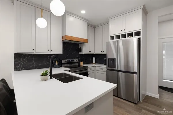 a kitchen with a refrigerator and a stove top oven