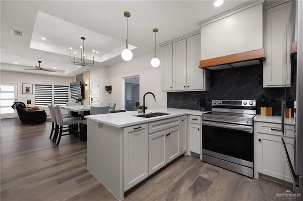 a kitchen with a stove cabinets and wooden floor